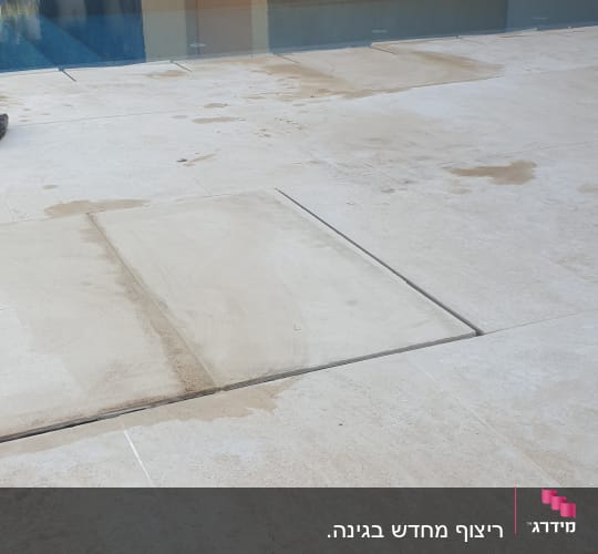 רצפת אבן עם סימני שיפוץ ליד בריכה